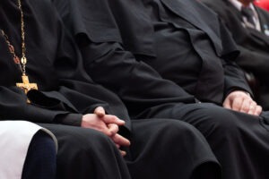A gathering of clergy members sit near each other. Call a Connecticut clergy abuse lawyer.