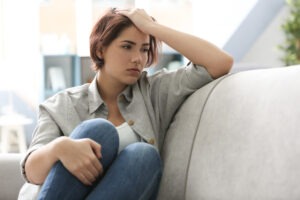 Worried young woman on a couch.
