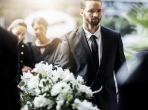 family carrying coffin at funeral