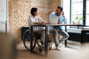 woman in wheelchair sitting with coworker